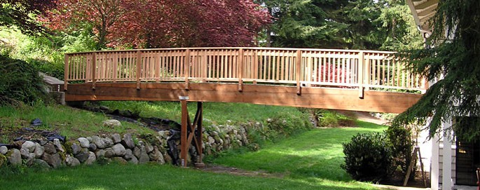 view of Bridge from yard, shows the gental arch of the structure and cedar railing. Anacortes Washington 98221
