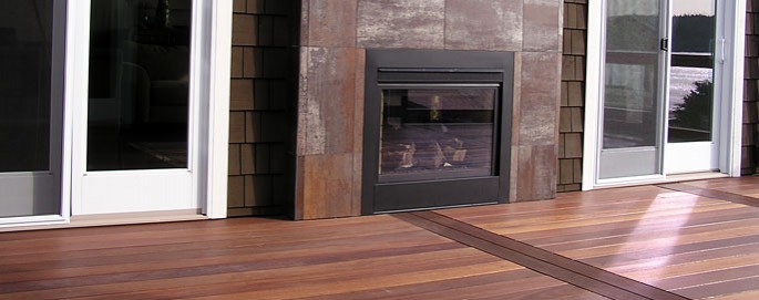 Anacortes Mahogany Deck with exterior gass fireplace. the fireplace surraound is finished with tile thate looks like cor-ten steel.