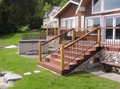 Brazilian Redwood deck. The railing on this project is powder coated steel with tropical hardwood top cap, the posts are round cedar with solid copper caps